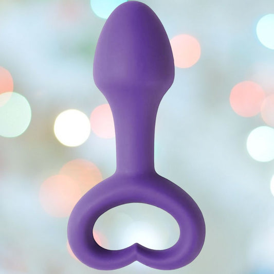 The LoveLife Explore Pleasure Anal Plug by OhMiBod rests against a blurred background with soft bokeh lights, enhancing its allure as a pleasure toy. 1080