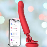 The Lovense Mission 2 Vibrating Suction Cup Dildo in red is shown next to a smartphone using the Lovense Remote app with settings options. A softly blurred, multi-colored light background highlights its advanced Touch-Sense Technology.