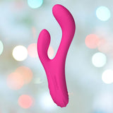 The Lovense Osci 3 Warming App-Controlled Rabbit Vibrator, a pink dual-ended oscillating device for G-spot stimulation, rests against a blurred backdrop, highlighted by soft circular light spots in various colors.