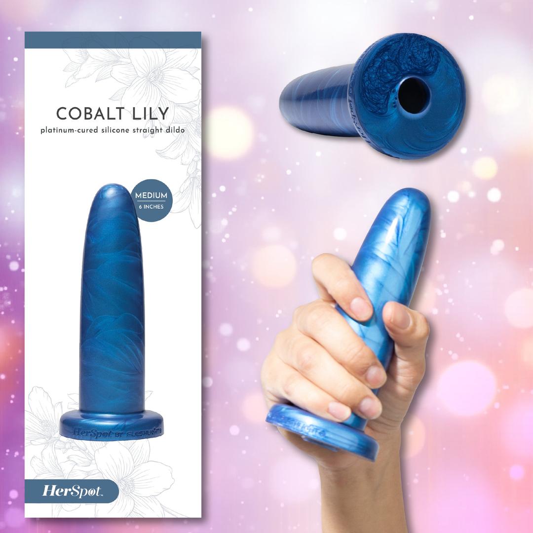 A hand holds the Fleshlight HerSpot Cobalt Lily Dildo, a blue marble-patterned, 6-inch platinum-cured silicone straight dildo by Fleshlight, next to its packaging.