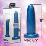 A blue Fleshlight HerSpot Cobalt Lily Dildo, 6 inches long with a marbled pattern and flared base, stands upright beside its packaging, offering medium-sized pleasure for those seeking new sensations.