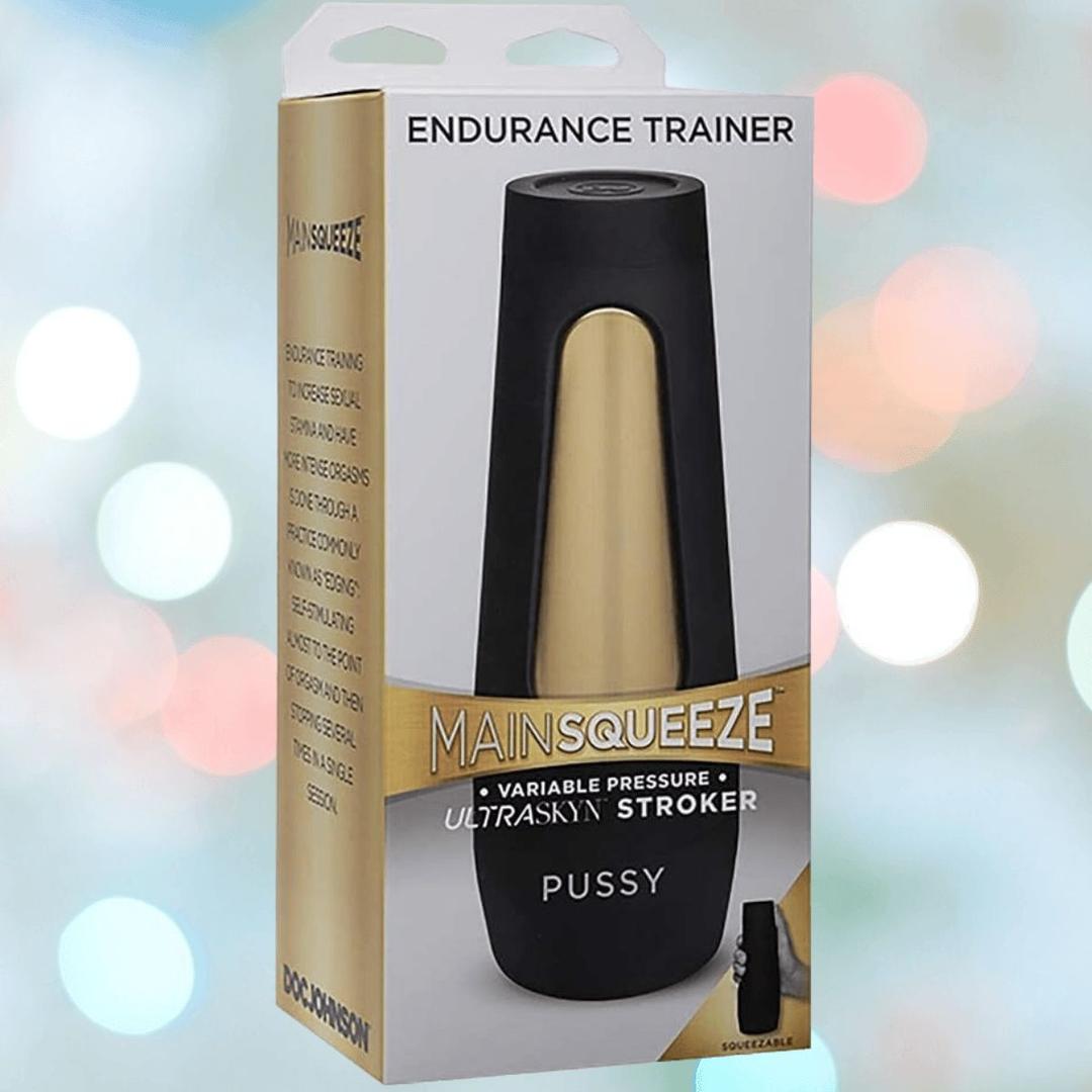 The Doc Johnson Main Squeeze Endurance Trainer Stroker Pussy - Vanilla comes in black and gold packaging, with blurred colorful lights in the background.