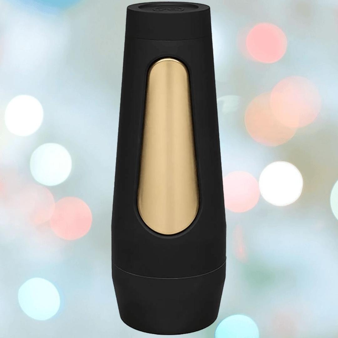 The Doc Johnson Main Squeeze Endurance Trainer Stroker Pussy - Vanilla, a black and gold cylindrical device with a modern design and ULTRASKYN sleeve, stands upright against a colorful bokeh background.