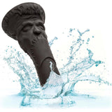 The CalExotics Monster Dong Frankenstein’s Monster, a black waterproof suction cup toy made of premium liquid silicone, splashes into clear water. Featuring a stitched mouth and furrowed brow, it delivers a monster-inspired look.
