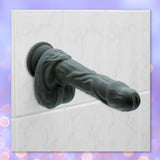 The BMS Naked Addiction Silicone Rotating & Thrusting Dildo - Noir 8.6" with a lifelike texture is displayed on a white wall.