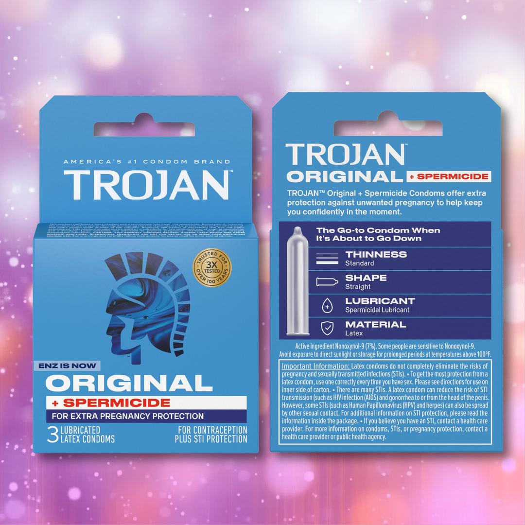 A blue box of Trojan ENZ Armor Spermicidal Condoms is displayed, featuring information about extra pregnancy protection, lubrication, size, shape, and material details, with the signature helmeted profile logo. Highlighted as standard thickness condoms with added spermicidal lubricant for enhanced security, this trusted Trojan product is shown against a pink bokeh background.