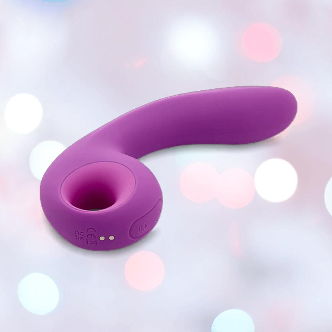 The NOVEL CREATIONS USA Nu Sensuelle Nubii Raine Tapping Vibrator with Warming and Turbo Boost in purple is shown against a softly blurred background with pastel bokeh lights. Its waterproof silicone body features a curved shape and circular opening at one end.