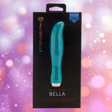 Presented against a blurred pink and purple bokeh background, the "Nu Sensuelle Velvet Touch Bella - Emerald Green" by NOVEL CREATIONS USA offers 20 vibration modes, XLR8 turbo boost, and velvet touch silicone for internal and external use.