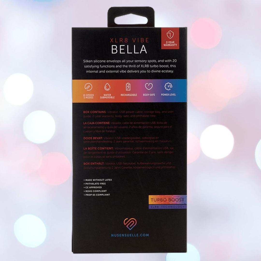 The Nu Sensuelle Velvet Touch Bella Vibrator with Turbo Boost by NOVEL CREATIONS USA features waterproof design, removable parts, turbo boost, and warranty info on the box. This body-safe silicone vibrator has a velvet touch finish against a blurred light background.