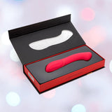 The Nu Sensuelle Velvet Touch Luna Vibrator with Turbo Boost by NOVEL CREATIONS USA is a hot pink, curved silicone toy offering 20 vibration patterns. Waterproof, it comes in a black and red box with molded insert, shown against a soft pink and blue background.