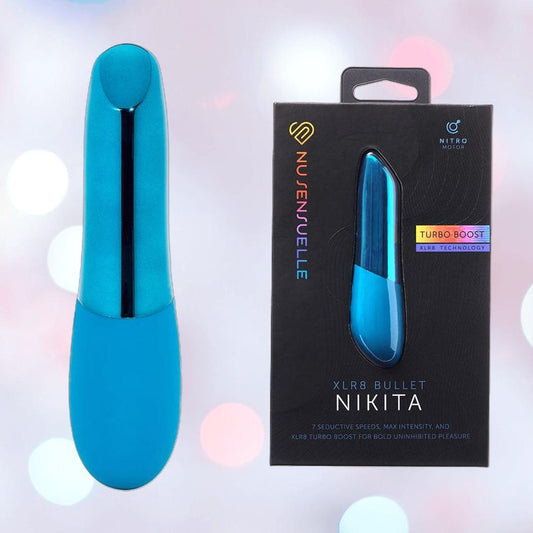A deep turquoise Nu Sensuelle Nikita High-Power Nitro Bullet Vibrator by NOVEL CREATIONS USA stands upright beside its sleek black box displaying the toy, "XLR8 Bullet Nikita," and "Turbo Boost" text on a soft, pastel bokeh background. 1080