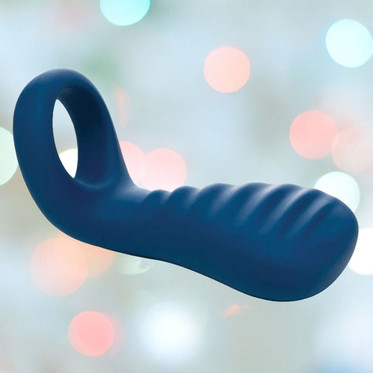 The OhMiBod blueMotion NEX|3-Navy Blue Couple's Ring, featuring a round handle and ridged silicone design in navy blue, is displayed against a blurred background of multicolored bokeh lights, emphasizing its compatibility with the OhMiBod Remote App for an enhanced experience. 1080