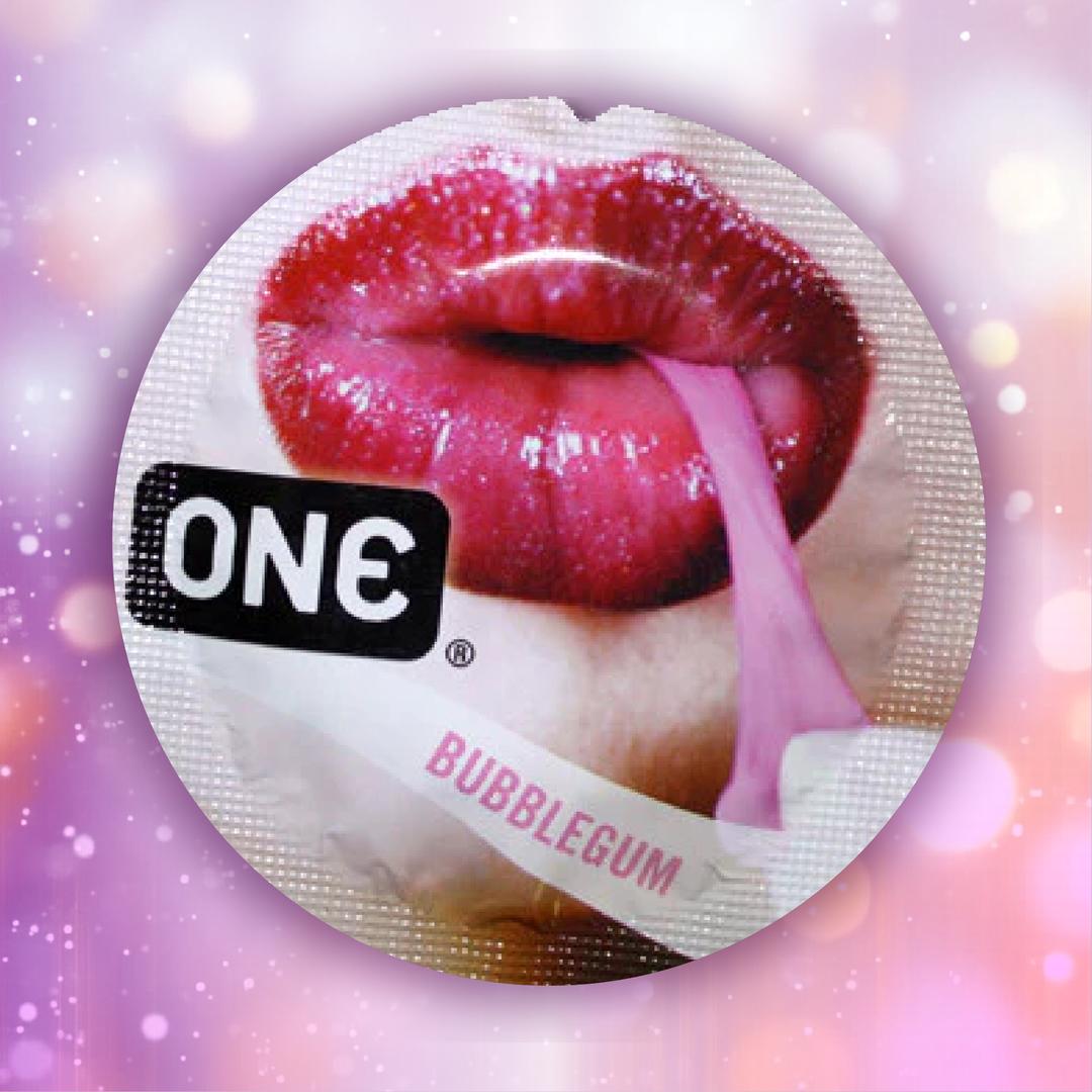 A round wrapper labeled "ONE" and "Bubblegum" features glossy red lips and a pink strip, suggesting the ONE Bubblegum Flavored Condoms, set against a blurred pink and purple bokeh background.