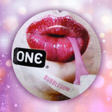 A round wrapper labeled "ONE" and "Bubblegum" features glossy red lips and a pink strip, suggesting the ONE Bubblegum Flavored Condoms, set against a blurred pink and purple bokeh background.