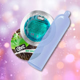 Two circular wrappers—one blue, one green—with "ONE" branding, and an unrolled ONE "Mint Chocolate" Flavored Condom are displayed against a pink and purple bokeh background.