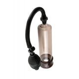 Introducing the Pump Worx Beginners Power Penis Pump by Pipedream: This clear cylindrical device features a flexible black hose and rubber bulb attachment, complemented by a sturdy black ring at the base. Meticulously designed for effective suction, it promises reliable erection enhancement.