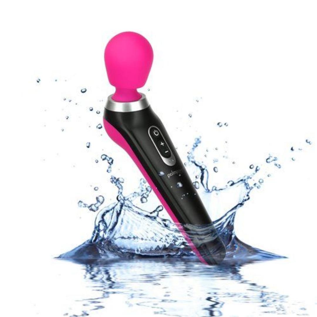 The BMS PalmPower Extreme Wand Massager - Pink features a black and pink design with a rounded silicone head, shown splashing into water to emphasize its waterproof and rechargeable handheld wand construction.