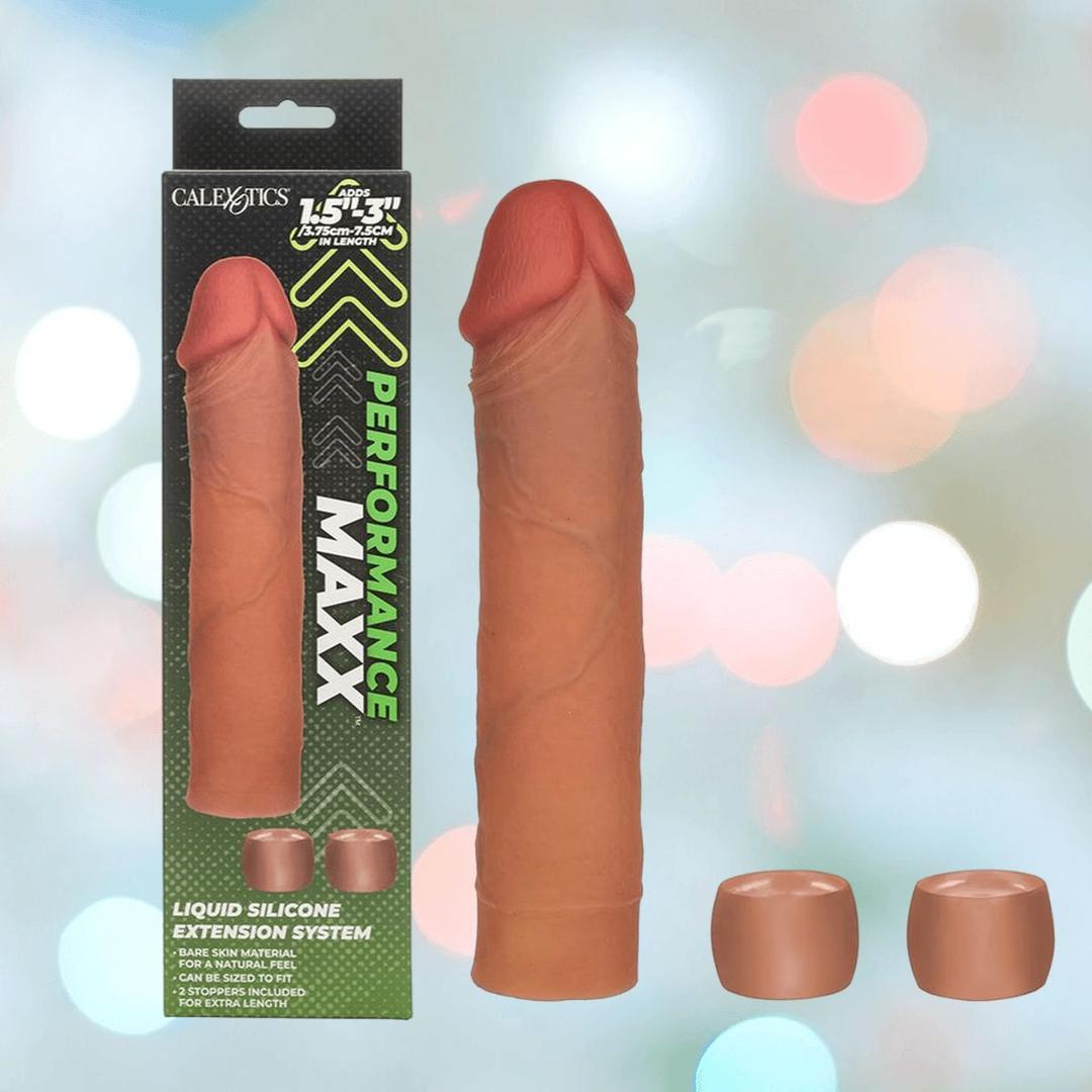 The image features the CalExotics Performance Maxx Liquid Silicone Extension System - Brown, its "Performance Maxx" packaging, and two cap-like attachments, all displayed against a colorful, blurred background.