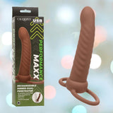 The CalExotics Performance Maxx Rechargeable Ribbed Dual Penetrator - Brown is displayed beside its packaging, showcasing USB rechargeability and multiple functions. The image features a light background with soft, blurred circles.