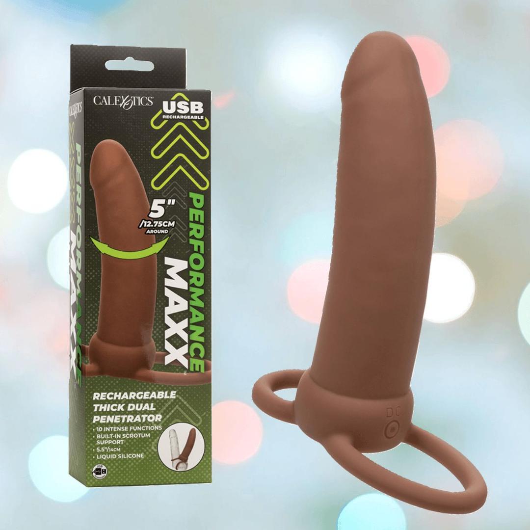 The CalExotics Performance Maxx Rechargeable Thick Dual Penetrator in brown, featuring dual rings and a USB rechargeable design, is shown beside its branded packaging marked “5”/12.75cm.”.