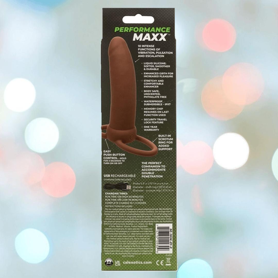 The image shows packaging for CalExotics Performance Maxx Rechargeable Thick Dual Penetrator - Brown, a silicone anal plug with a ring handle, designed for dual penetration. Colorful lights in the blurred background highlight its bold look.