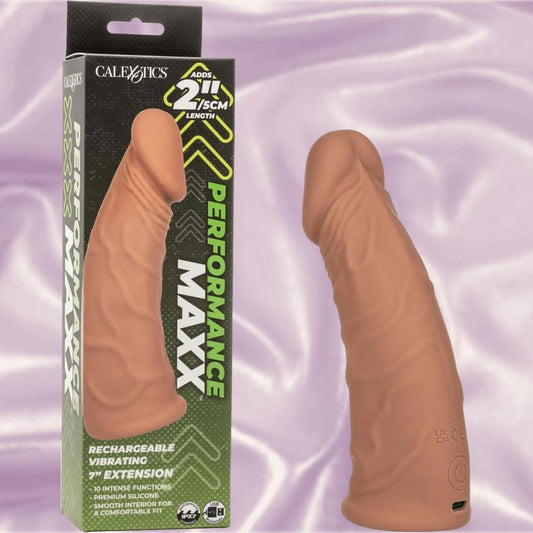 The CalExotics Performance Maxx Rechargeable Vibrating Extension-Brown 7" stands beside its box, which touts a 2-inch length boost and multiple vibration functions for enhanced pleasure. 1080