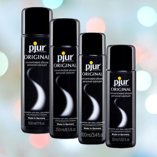 Four bottles of Pjur Original BodyGlide Silicone Lubricant from the Pjur brand are displayed against a blurred bokeh background. The hypoallergenic bottles range in size from 30ml to 500ml, and are all black with white and gray text. Each bottle is labeled "Made in Germany. 1080