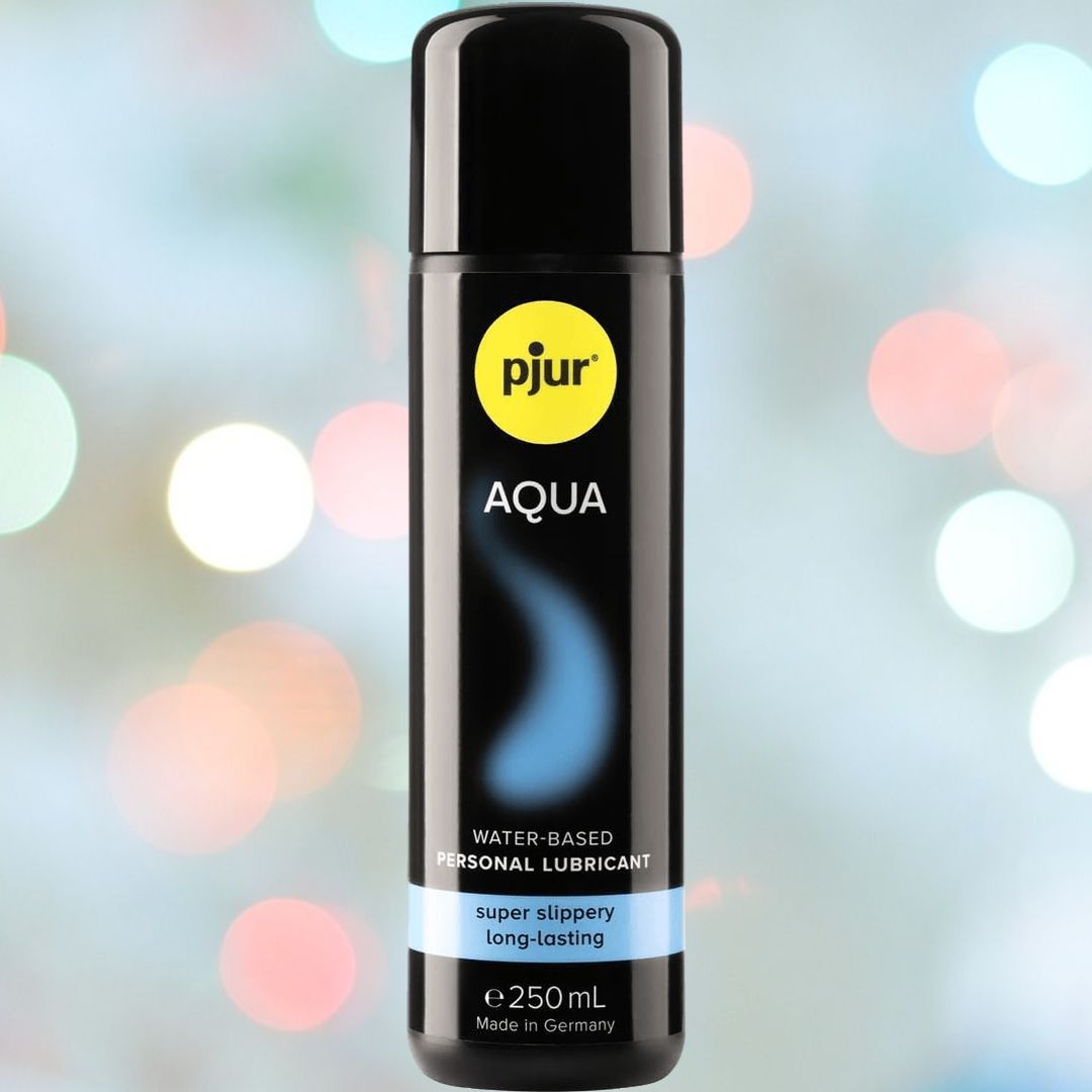 The sleek black bottle of Pjur Aqua water-based lubricant takes center stage against a blurred, colorful background adorned with circular light spots. Promising a non-irritating experience, the 100 mL (3.4 oz) bottle is labeled "super slippery, long-lasting.