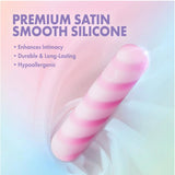 The Play With Me Sugar Crush - Pink by Blush Novelties is a pink and white striped clitoral vibrator made from premium, satin-smooth, hypoallergenic silicone. Its waterproof design enhances intimacy, shown resting on a pastel gradient background.