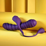The Playboy Twisted Playground by Evolved Novelties, a purple silicone double-ended toy with curved, ribbed shafts, is shown on a yellow surface against a yellow background.
