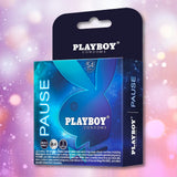 A box of Playboy Condoms - Pause Play Longer (3 premium lubricated condoms, 54mm) with the iconic bunny logo and blue design is shown against a pink and purple bokeh background.