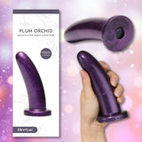 A hand holds the Fleshlight HerSpot Plum Orchid Dildo, a medium 5.7-inch platinum-cured silicone toy. Shown from two angles alongside its packaging, labeled with the Fleshlight brand and product name.