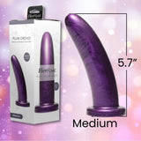 A Fleshlight HerSpot Plum Orchid Dildo by Fleshlight, featuring a purple marble texture, stands next to its packaging. This luxury silicone dildo is medium-sized at 5.7 inches tall, set against a soft pink bokeh background.