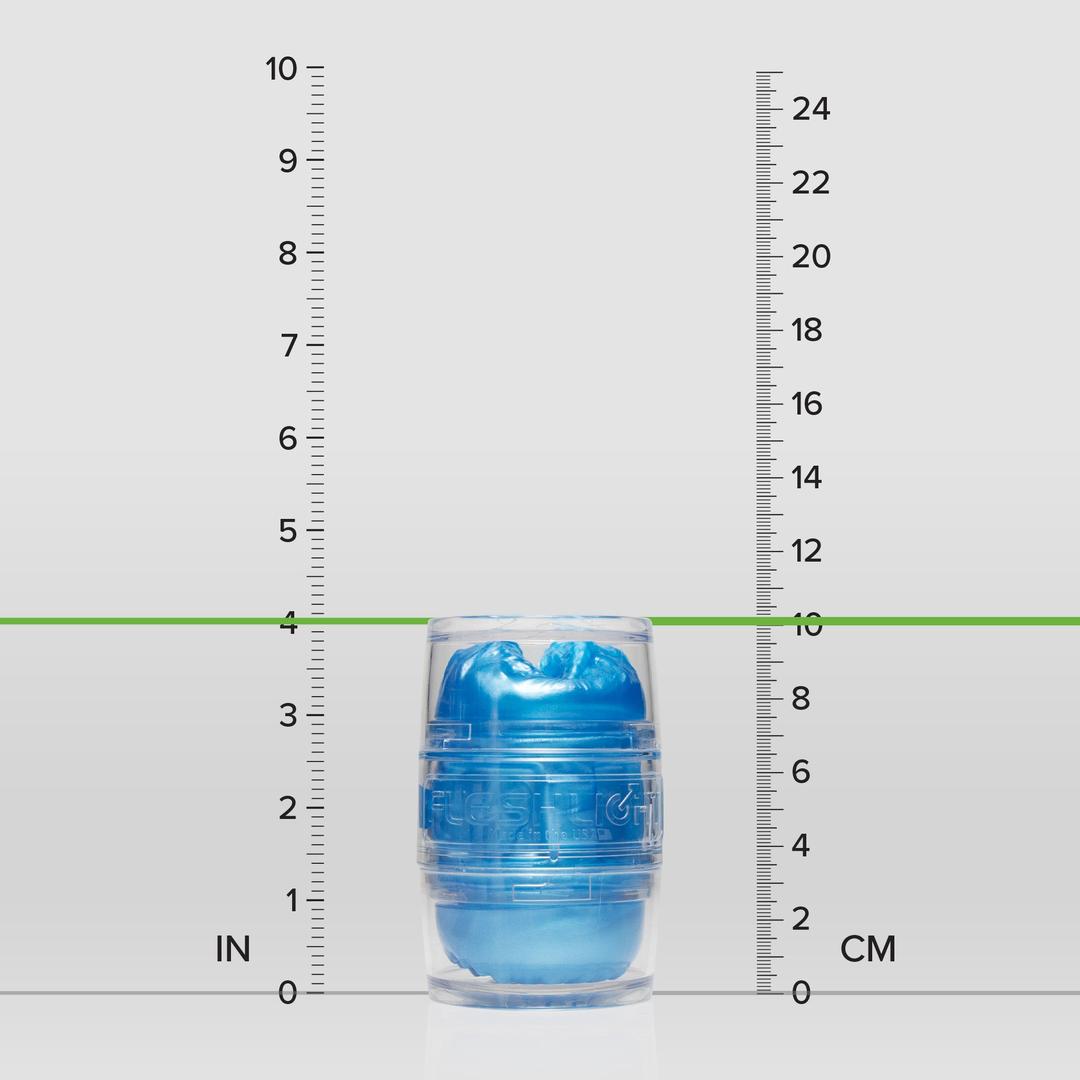 A transparent capsule containing a blue object, the Fleshlight Quickshot Alien Blue Male Masturbator (Mouth & Butt) by Fleshlight, stands upright between inch and centimeter rulers, measuring about 4 inches (10 cm) tall.