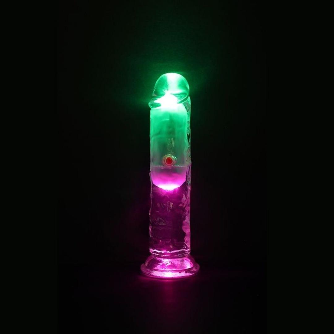 The RealRock Wireless Rechargeable LED Vibrating 6" by Shots America glows with green and pink lights against a black background.