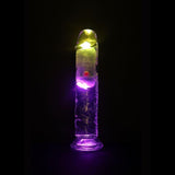 The RealRock Wireless Rechargeable LED Vibrating 7" by Shots America, a transparent dildo with yellow and purple LED lights inside, stands upright against a black background.