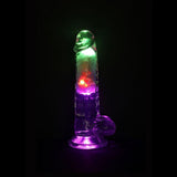 The RealRock Wireless Rechargeable LED Vibrating With Balls 7" by Shots America glows green, purple, and red in the dark, creating a captivating effect with its phallic-shaped transparent design.