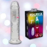 The RealRock Wireless Rechargeable LED Vibrating 7" by Shots America is displayed beside its packaging, marked "REALROCK," highlighting product details and a vibrant background.