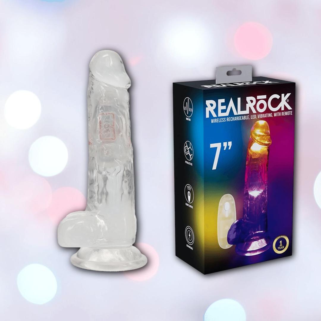 The RealRock Wireless Rechargeable LED Vibrating With Balls 7" by Shots America stands upright next to its box, which is branded “REALROCK” and shows the multicolor LED dildo glowing inside.