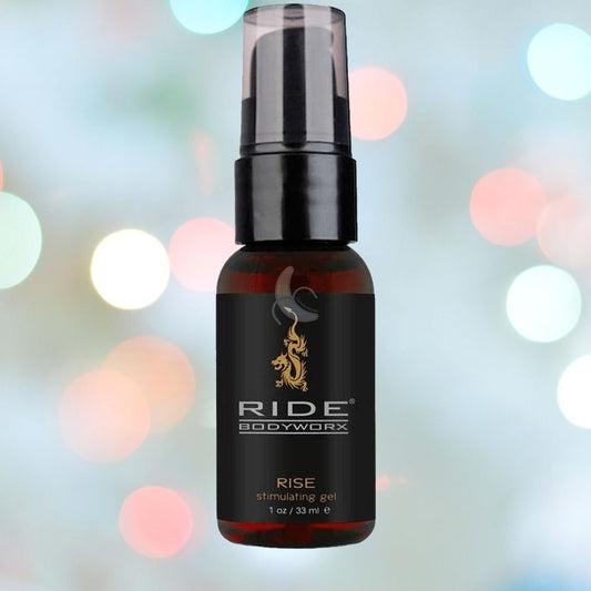 The Ride Bodyworx Rise Stimulating Gel for Men by Sliquid, infused with organic botanicals, is presented in a bottle featuring a sleek black label and pump top. Behind it, a pattern of colorful bokeh lights enhances the vibrant allure. 1080