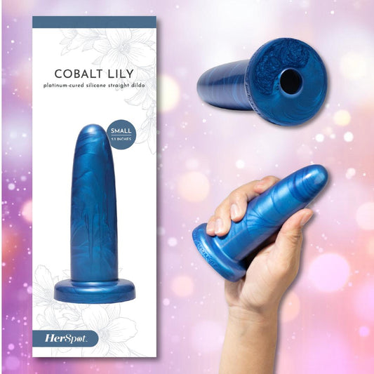 A hand holds the Fleshlight HerSpot Cobalt Lily Dildo next to its packaging. The soft pink and purple backdrop, with delicate floral accents, creates an empowering pleasure scene. 1080