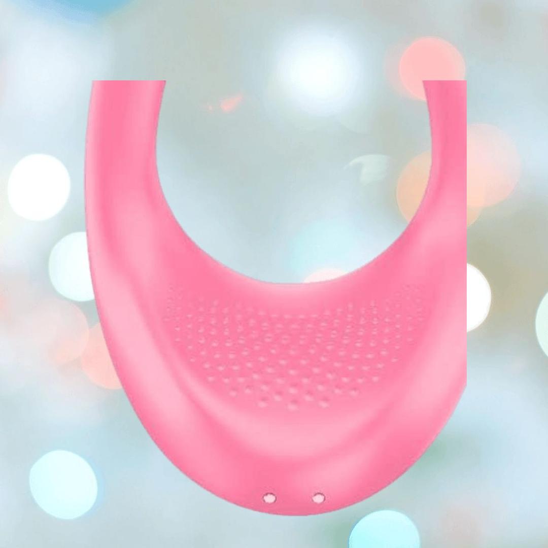 The Satisfyer Endless Joy Vibrator for Couples in pink features a textured U-shaped design with two small holes at the base, shown against a softly blurred background with circular light accents.