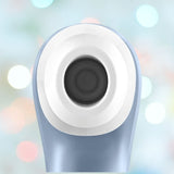 Close-up of a Satisfyer Pro 2 Air Pulse Clitoral Stimulator by Satisfyer, showing a central circular black sensor with a white ring, set against a blurred background with colorful lights.