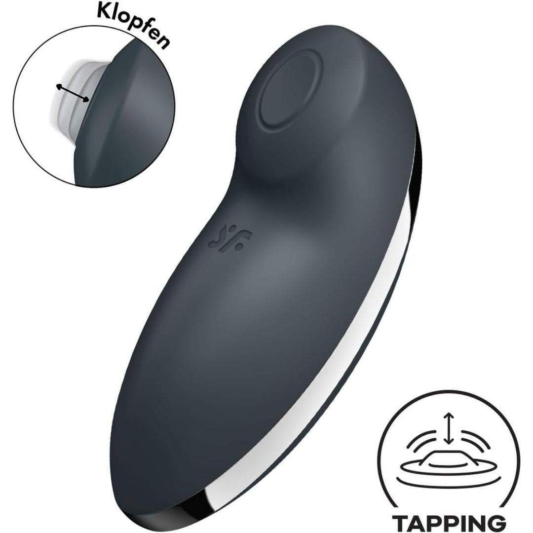 The Satisfyer Tap and Climax 2 Lay-On Vibrator by Satisfyer is a black, curved personal massager with a round top button. An inset highlights its tapping motion, with “TAPPING” and an icon in the lower right corner.