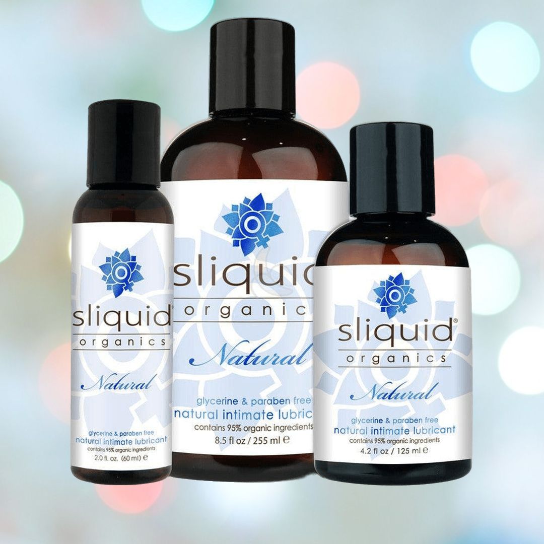 Three bottles of Sliquid Organics Natural Lubricant with Aloe are showcased. Their labels emphasize the glycerine and paraben-free formulation, boasting 95% organic ingredients. These water-based lubricants, available in different sizes, are set against a vibrant, blurred background.