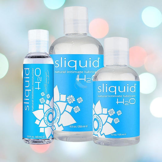 A trio of Sliquid H2O Water-Based Lubricant bottles by Sliquid are set against a gently blurred background featuring shades of light blue and green. Each hypoallergenic bottle, ideal for sensitive skin, comes in different sizes and showcases blue labels embellished with white floral patterns. 1080