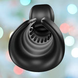 A black, spiral-shaped object resembling a stylized shell is featured against a blurred background with gentle pastel bokeh lights, echoing the design of the Snail Vibe Evo Rechargeable Male Masturbator by Snail Vibe, crafted for ideal synchro-stimulation.