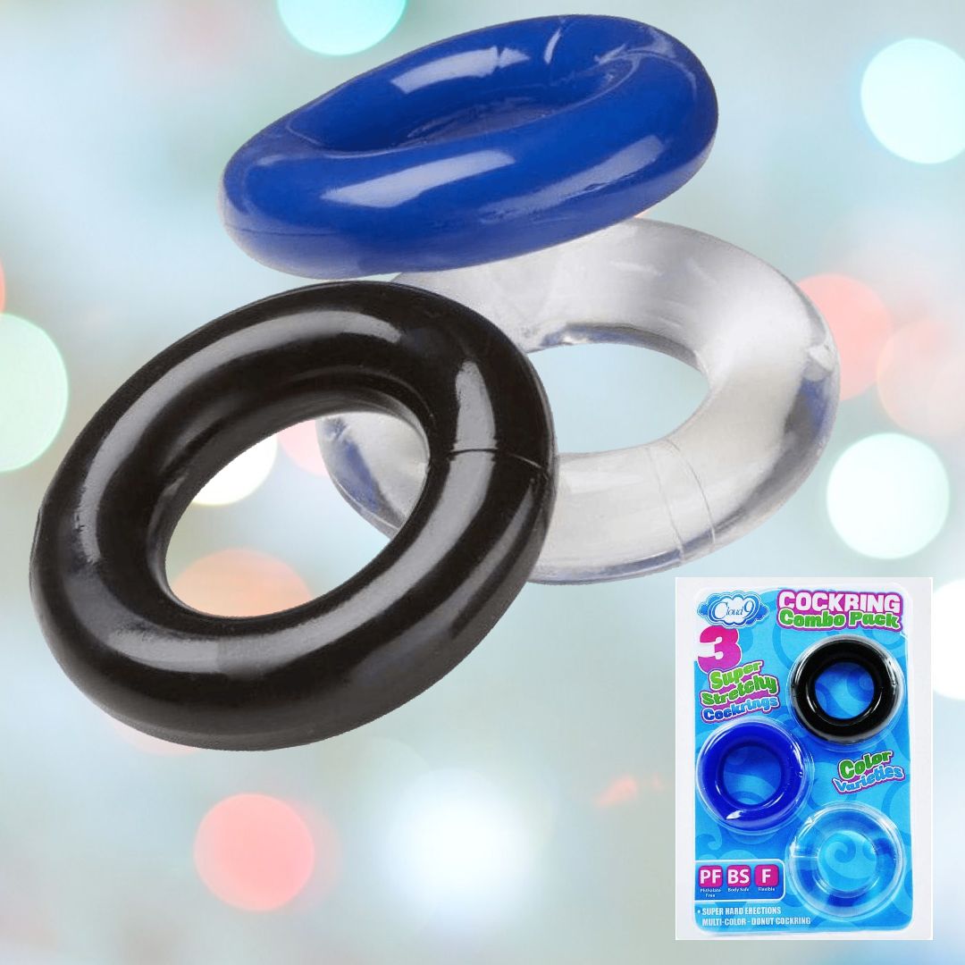 Image of a set of Cloud 9's Super Stretchy Cock Ring (3-Pack) featuring one blue, one black, and one clear ring. These rings, designed to aid with premature ejaculation, are arranged in an overlapping fashion against a blurred backdrop. In the lower right corner, a product box can be seen displaying the rings and packaging details.