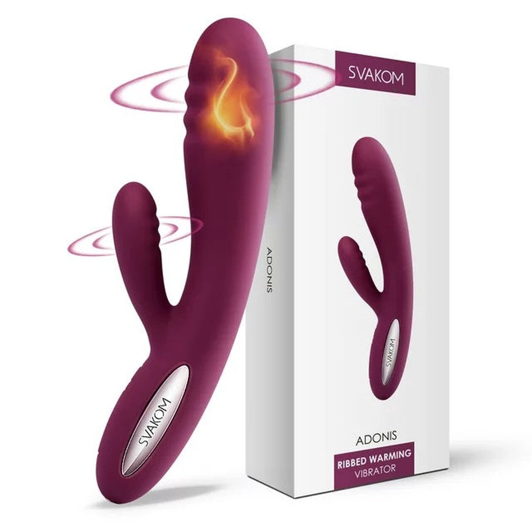 A Svakom Adonis Ultra Soft Double-Motor G-Spot & Clit Warming Vibrator, featuring a purple ribbed design and dual attachments, crafted from body-safe silicone, is displayed alongside its matching box. Both the vibrator and the box prominently feature the brand name "Svakom" and product name "Adonis," highlighting its function as a G-Spot vibrator.