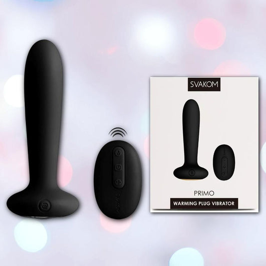 A black silicone Svakom Primo Heating Butt Plug with a wireless remote is pictured beside its packaging, featuring the product name and brand "Svakom" against a soft, bokeh background. 1080